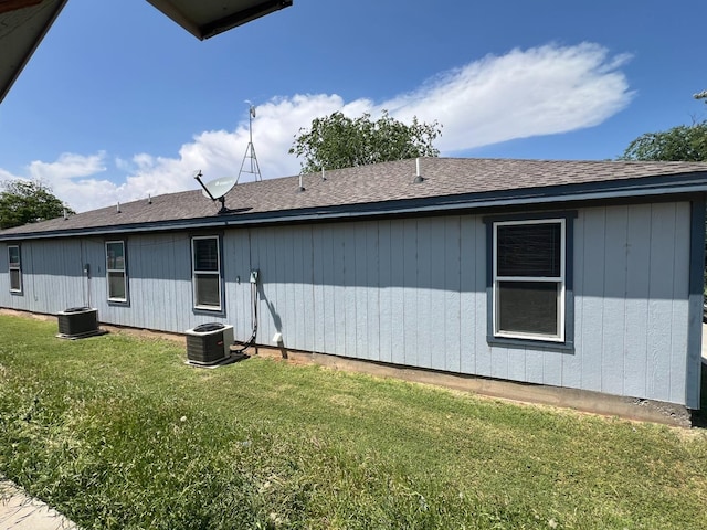 back of house featuring central AC and a yard