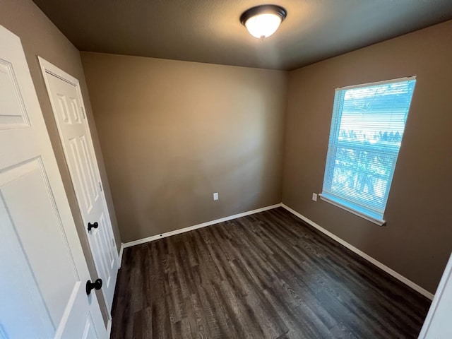 unfurnished room with dark hardwood / wood-style floors