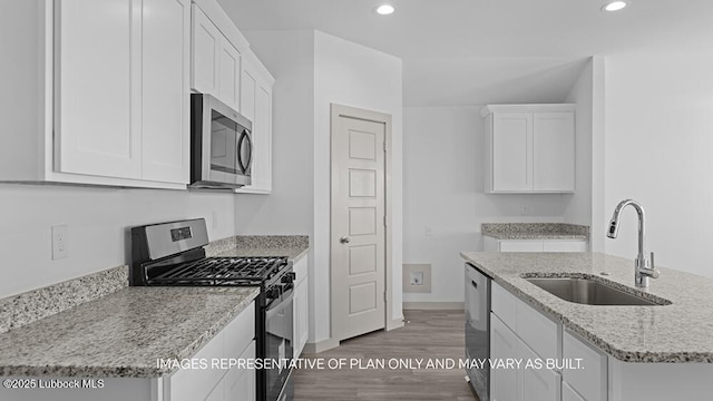 7816 93rd St, Lubbock, TX 79424 - kitchen featuring appliances with stainless steel finishes, recessed lighting, white cabinets, light wood-style floors, and light stone counters