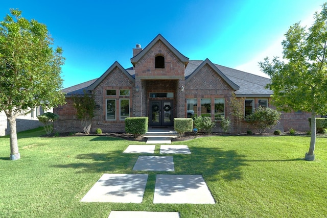 1403 Knight Ave, Wolfforth, TX 79382 - view of front of property featuring a chimney, brick siding, french doors, and a front lawn