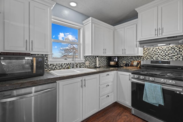 kitchen with sink, stainless steel appliances, dark hardwood / wood-style floors, white cabinets, and decorative backsplash