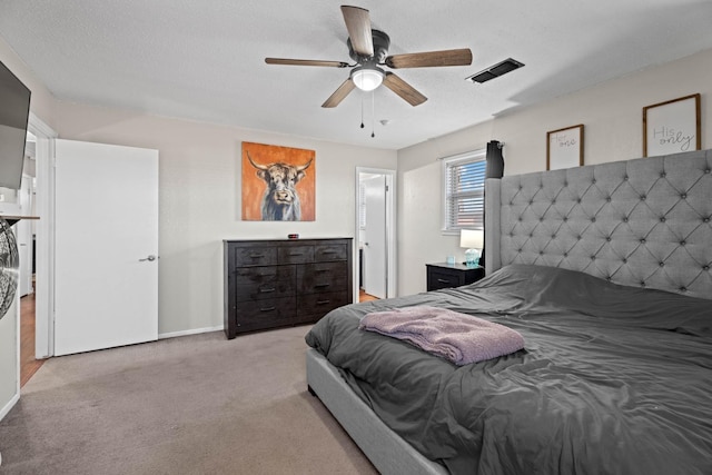 bedroom featuring light colored carpet, a textured ceiling, and ceiling fan