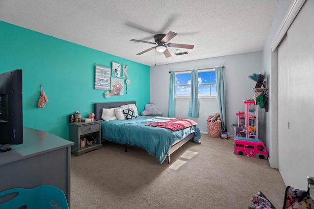 bedroom with a textured ceiling, ceiling fan, and carpet flooring