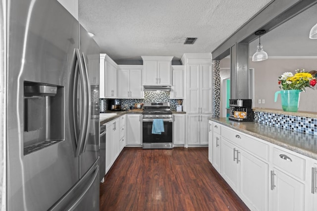 kitchen with tasteful backsplash, decorative light fixtures, appliances with stainless steel finishes, dark hardwood / wood-style floors, and white cabinets