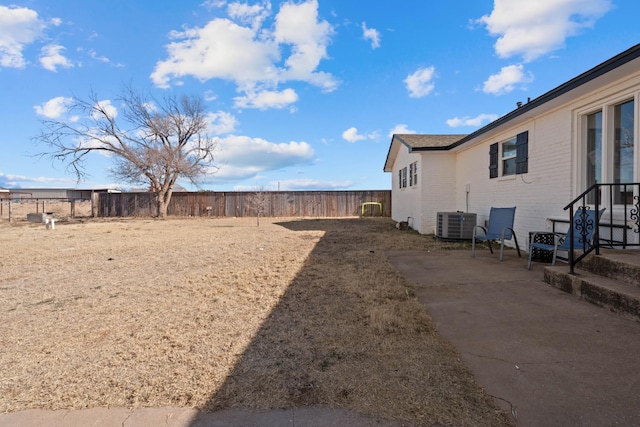 view of yard with central AC and a patio area