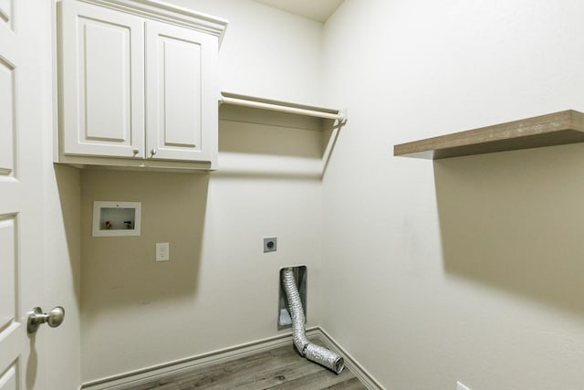 clothes washing area featuring hardwood / wood-style floors, hookup for a washing machine, hookup for an electric dryer, and cabinets