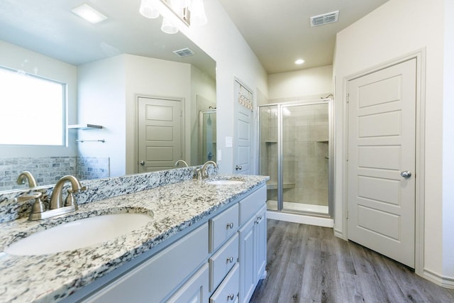 bathroom with wood-type flooring, an enclosed shower, and vanity