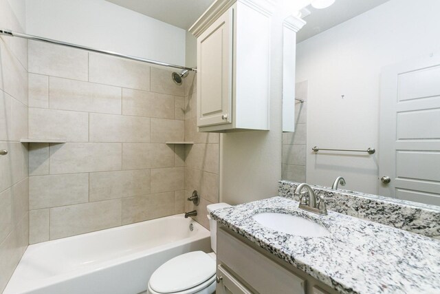 full bathroom with tiled shower / bath combo, vanity, and toilet