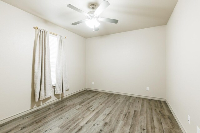 spare room with ceiling fan and light wood-type flooring