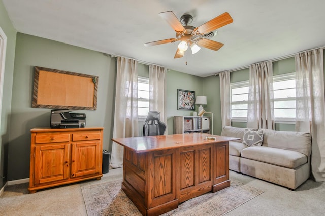 office space with plenty of natural light, light colored carpet, and ceiling fan