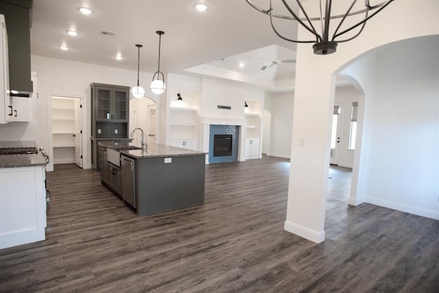 kitchen featuring sink, decorative light fixtures, dark hardwood / wood-style floors, ceiling fan, and a kitchen island with sink