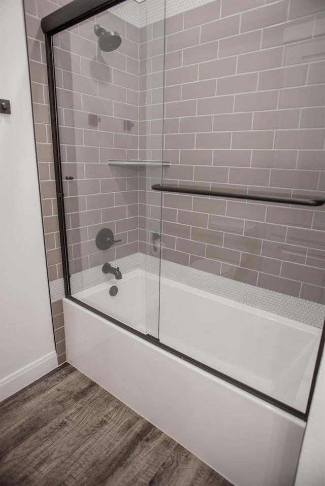 bathroom with wood-type flooring and enclosed tub / shower combo