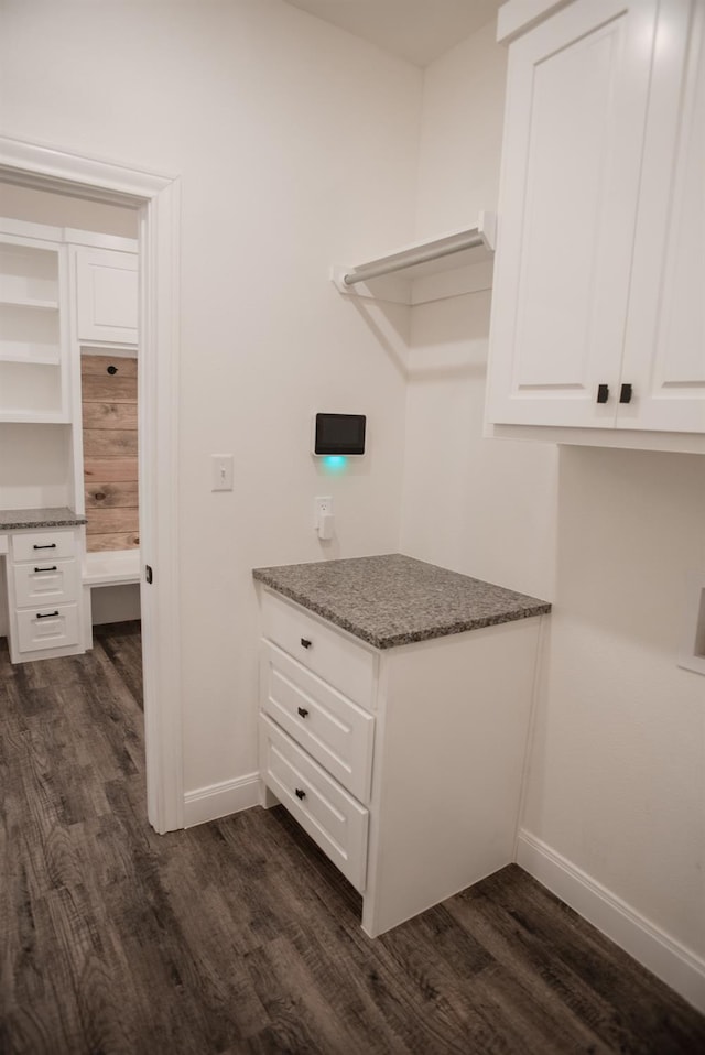 interior space with dark hardwood / wood-style flooring and built in desk