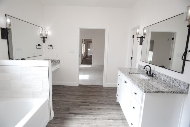 bathroom with vanity, hardwood / wood-style floors, and a bathtub