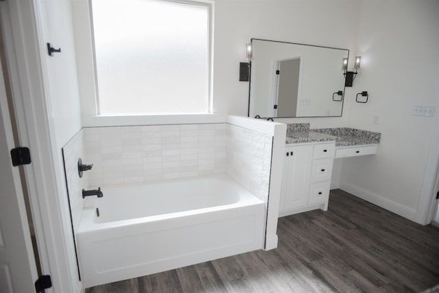 bathroom with vanity, a bath, and hardwood / wood-style floors