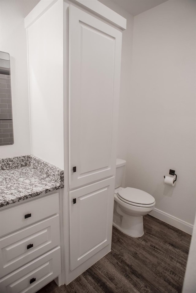 bathroom with vanity, toilet, and hardwood / wood-style floors