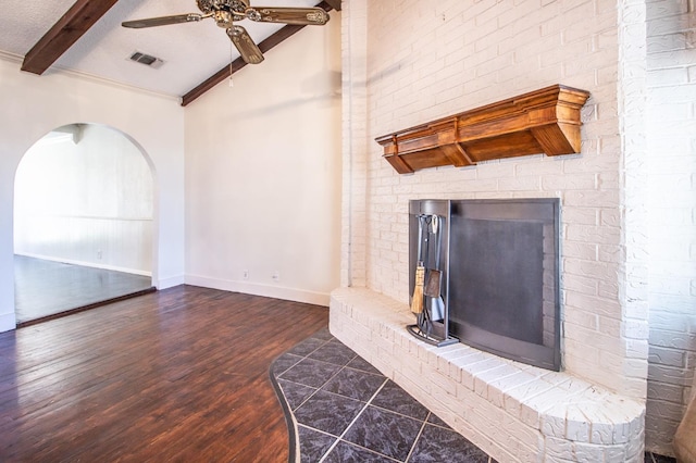 living room with a ceiling fan, wood finished floors, baseboards, a fireplace, and arched walkways