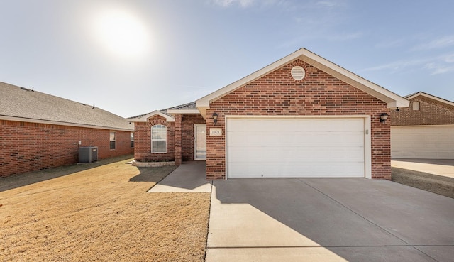 ranch-style home featuring a garage and central AC unit