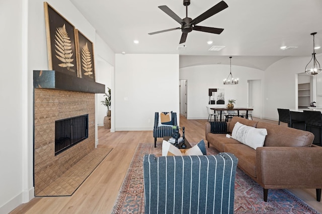 living room featuring hardwood / wood-style flooring and ceiling fan with notable chandelier