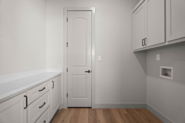 laundry room featuring cabinets, hookup for a washing machine, and light wood-type flooring