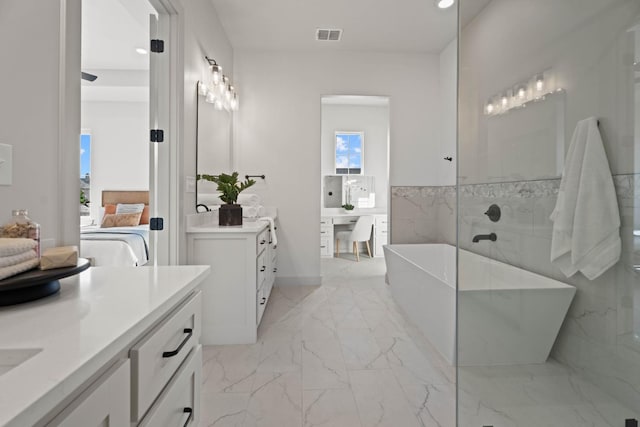 bathroom with vanity, a bathing tub, and tile walls