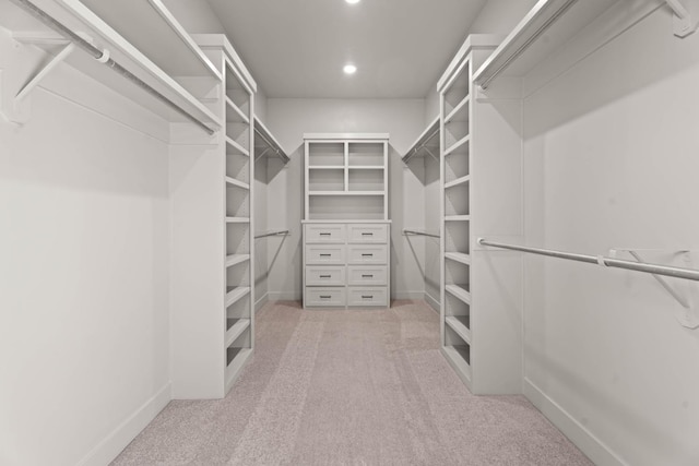 walk in closet with light colored carpet