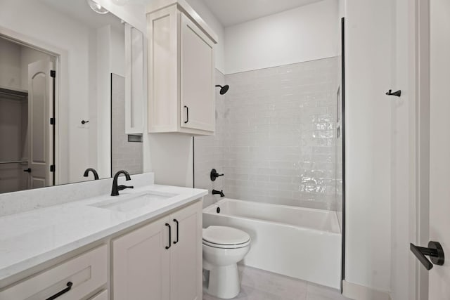 full bathroom featuring tile patterned flooring, tiled shower / bath, vanity, and toilet