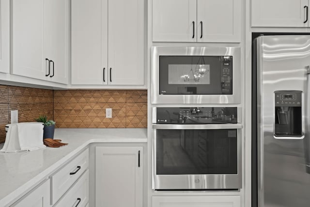 kitchen featuring tasteful backsplash, stainless steel appliances, light stone counters, and white cabinets