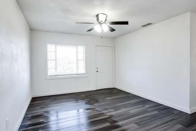 spare room featuring dark hardwood / wood-style floors and ceiling fan