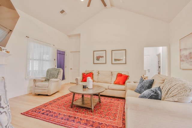 living room with hardwood / wood-style flooring, ceiling fan, high vaulted ceiling, and beam ceiling