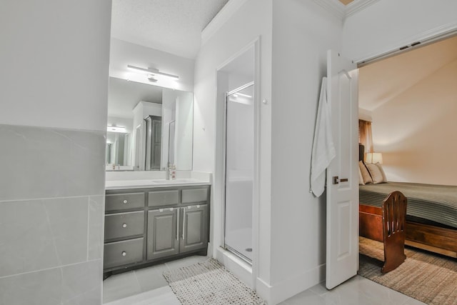 bathroom with tile patterned flooring, vanity, ornamental molding, walk in shower, and a textured ceiling