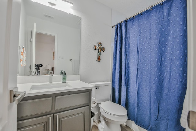 bathroom with vanity, toilet, and curtained shower