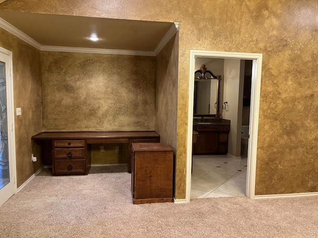 unfurnished office featuring light carpet, sink, crown molding, and built in desk