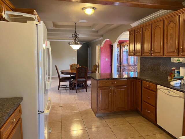 kitchen featuring decorative light fixtures, backsplash, light tile patterned floors, a raised ceiling, and white appliances