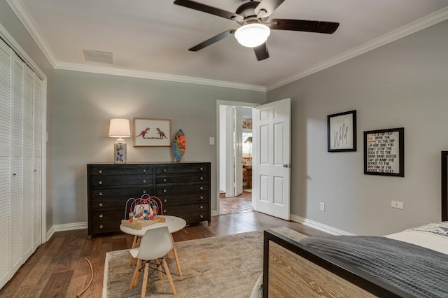 bedroom featuring dark wood-type flooring, ceiling fan, ornamental molding, and a closet