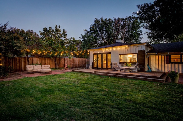 yard at dusk with outdoor lounge area and a deck