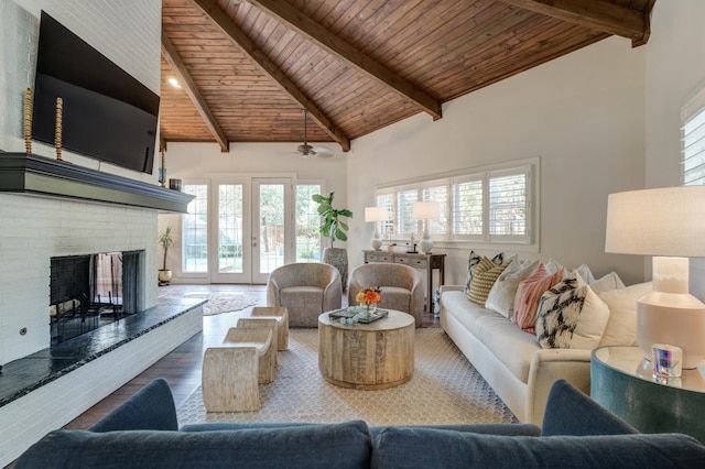 living room featuring wood ceiling, hardwood / wood-style floors, a brick fireplace, and beamed ceiling