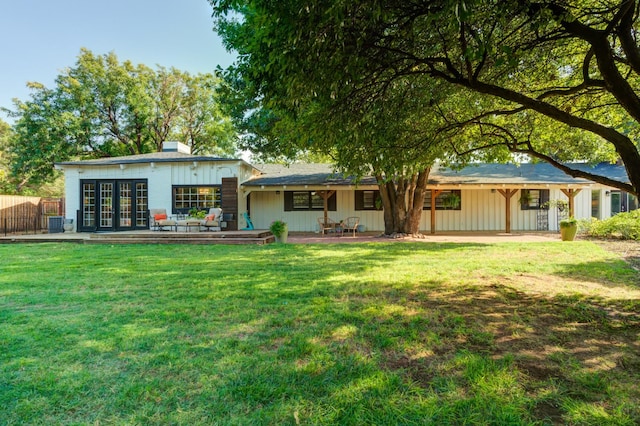 rear view of property with cooling unit and a lawn