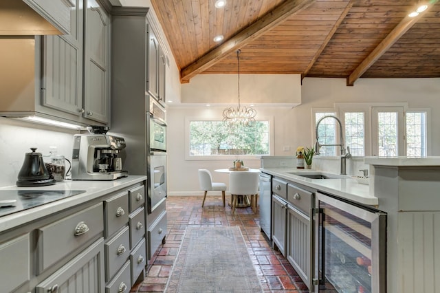 kitchen featuring gray cabinetry, beverage cooler, sink, and wooden ceiling