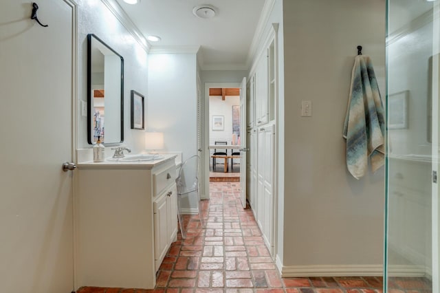 bathroom with vanity, a shower with door, and ornamental molding