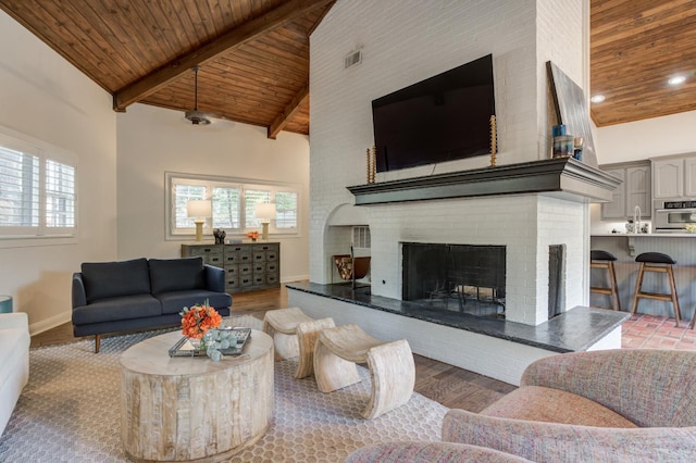 living room featuring high vaulted ceiling, wood-type flooring, a brick fireplace, wooden ceiling, and beamed ceiling