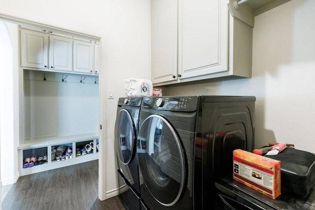 washroom with dark hardwood / wood-style flooring, washing machine and dryer, and cabinets