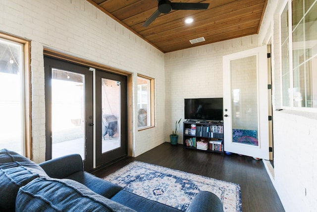 living room featuring brick wall, wooden ceiling, dark hardwood / wood-style flooring, and french doors