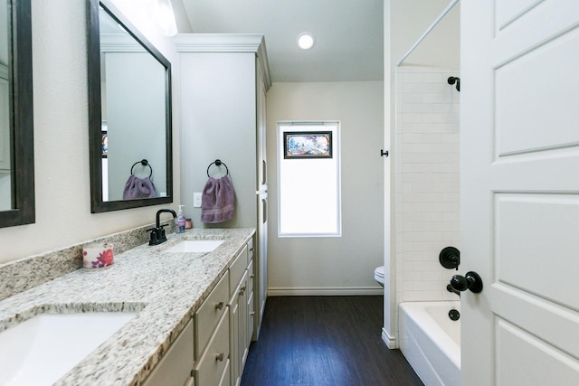 full bathroom featuring vanity, toilet, tiled shower / bath combo, and wood-type flooring