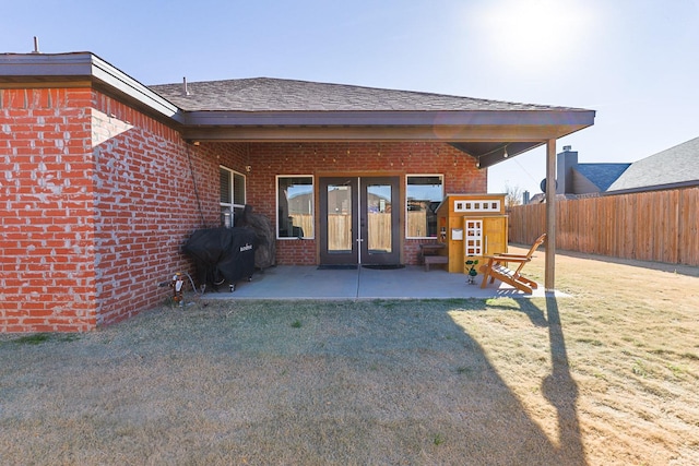 rear view of property featuring a yard and a patio area