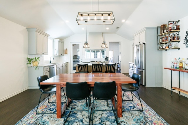 dining area with lofted ceiling, sink, and dark hardwood / wood-style flooring