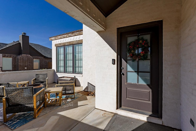 entrance to property featuring an outdoor living space and a patio