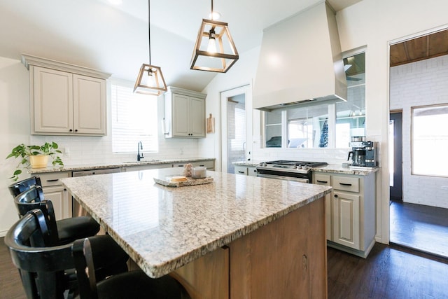 kitchen with a center island, custom range hood, and a breakfast bar