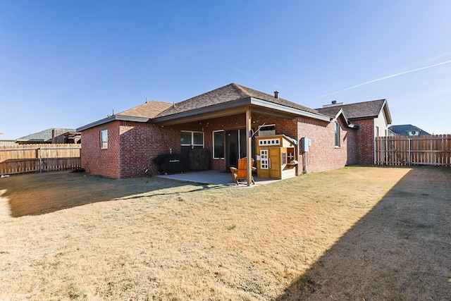 back of house with a yard and a patio area