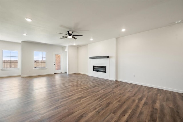 unfurnished living room featuring dark hardwood / wood-style flooring and ceiling fan